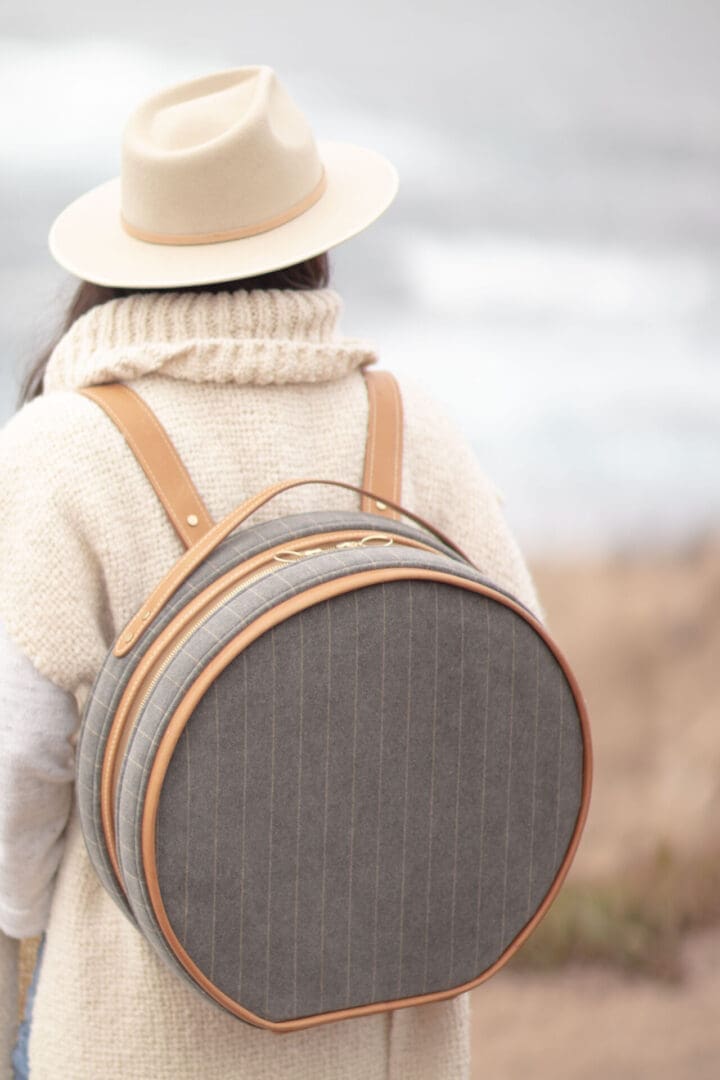 Woman wearing a round striped backpack.