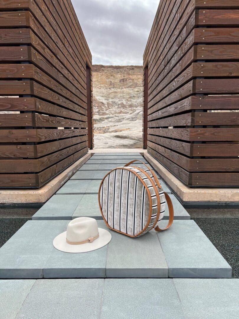 White fedora and round suitcase on walkway
