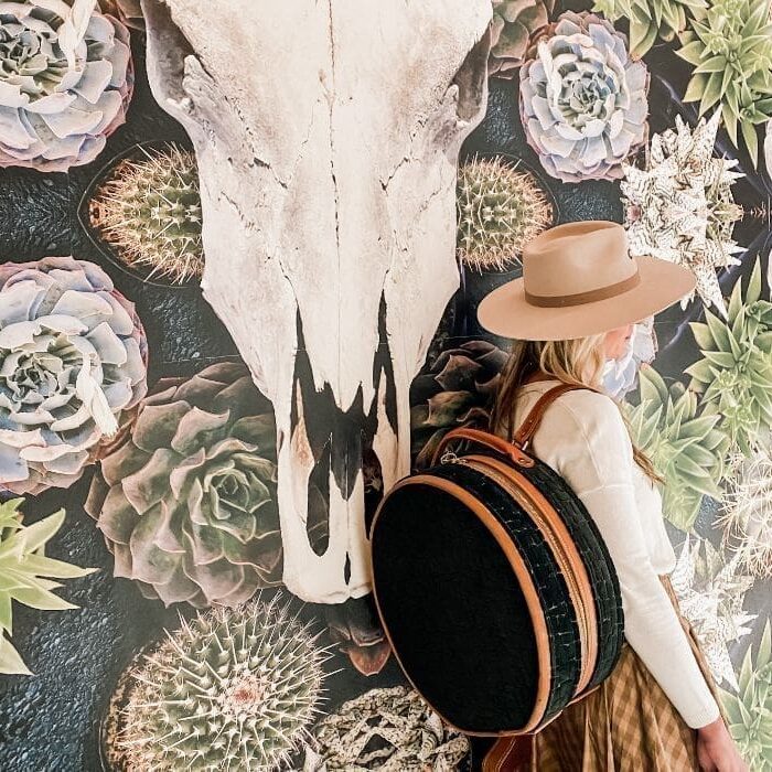 Woman with hat and round backpack.
