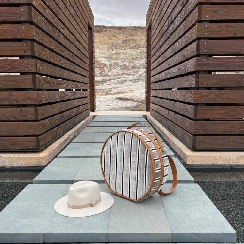 Striped round bag and hat on patio.